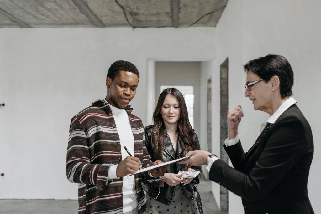 Three people reviewing documents in an office, discussing AFSL general obligations.
