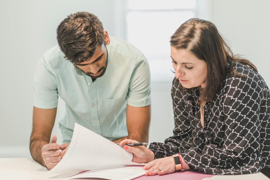 Financial advisors reviewing documents, potentially related to ASIC or AFS Licensee obligations.