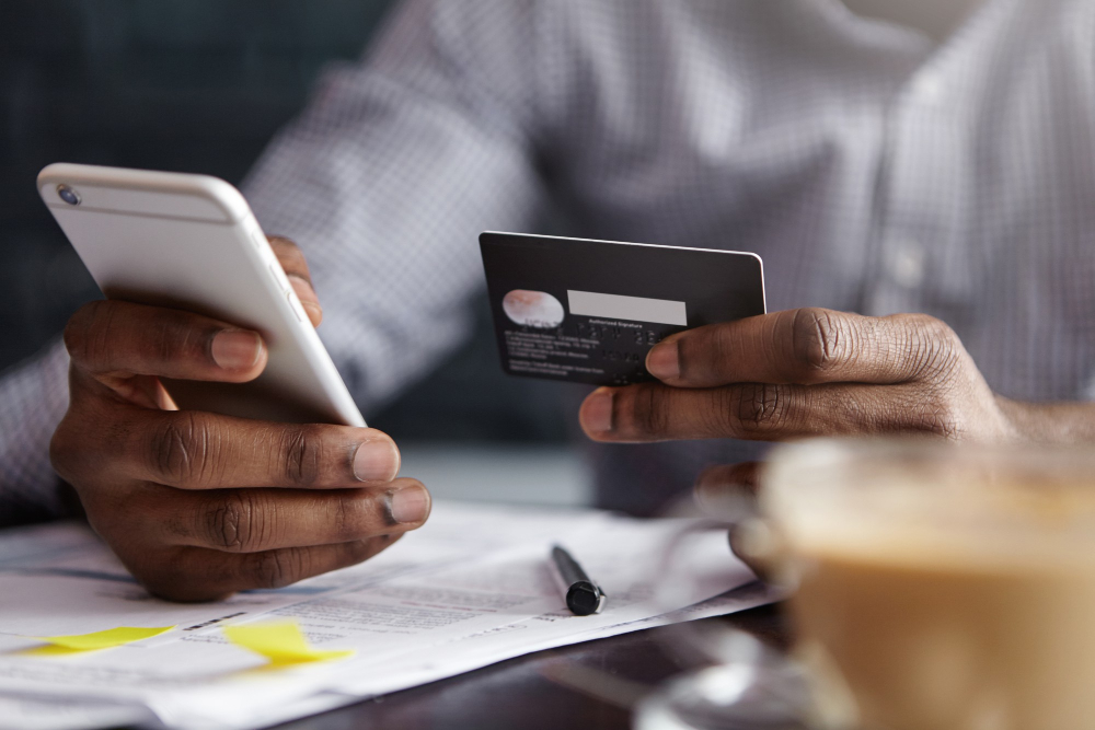 Person using a credit card and smartphone for online payment. BNPL Regulation in Australia context.