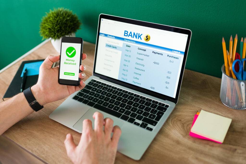 Online banking: Person using a laptop to view transactions and a phone showing "Money Received.
